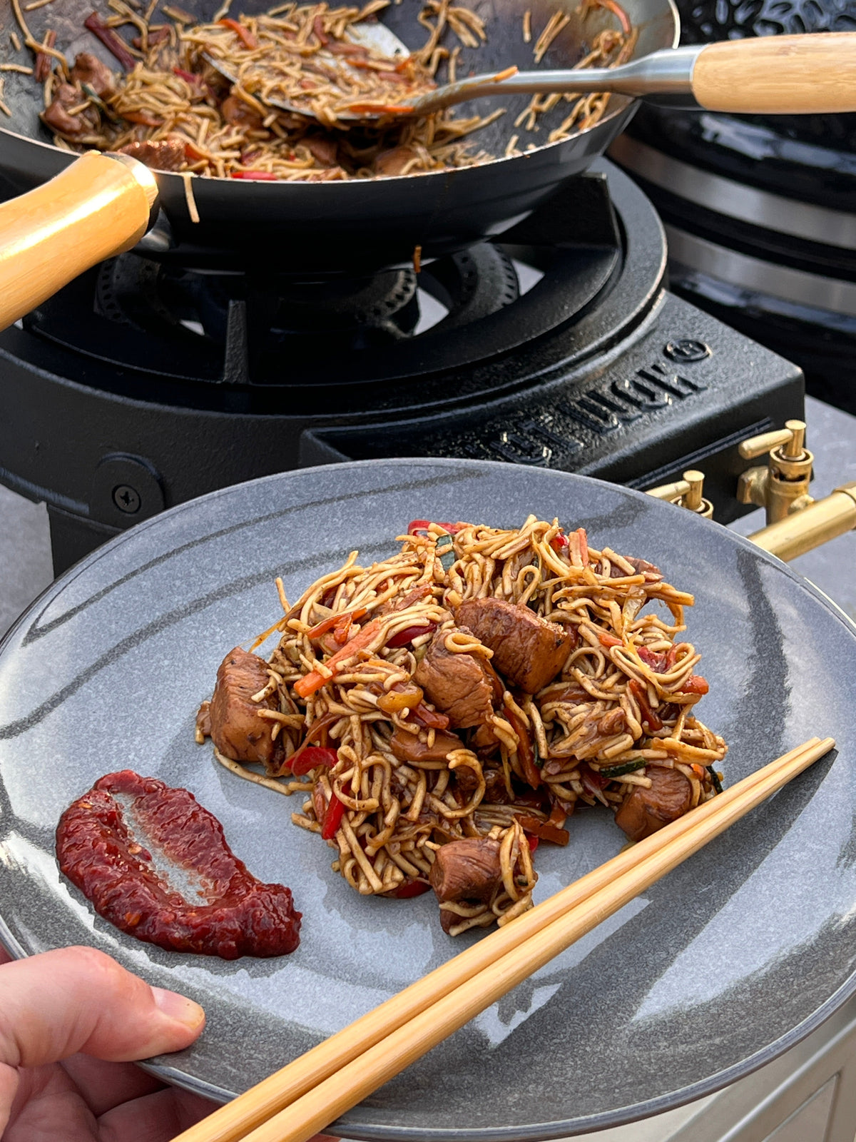 Chicken stir fry with noodles and fresh vegetables cooked in a wok